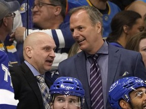 Tampa Bay Lightning coach Jon Cooper, right, and assistant coach Derek Lalonde talk during the third period of the team's NHL hockey game against the St. Louis Blues on Dec. 2, 2021, in Tampa, Fla.