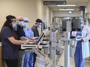 Head intensivist Dr. Ali Ghafouri, second left, meets with his health-care team doing his morning patient rounds in the intensive care unit at the Humber River Hospital during the COVID-19 pandemic in Toronto on Tuesday, April 13, 2021.