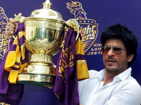 Bollywood actor Shah Rukh Khan displays the Indian Premier League (IPL) cricket trophy during a news conference at his residence in Mumbai May 30, 2012.