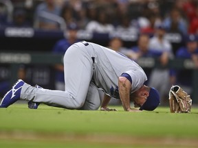 Los Angeles Dodgers reliever Daniel Hudson lies on the field after getting injured trying to field a ground ball during the eighth inning of a baseball game against the Atlanta Braves, Friday, June 24, 2022, in Atlanta.
