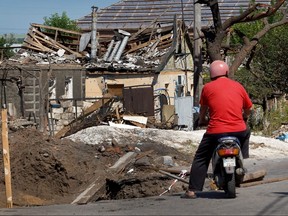Ein Mann hält inne, um sich ein Haus anzusehen, das kürzlich am 19. Juni 2022 in Druzhkivka, Ukraine, durch einen russischen Raketenangriff beschädigt wurde.