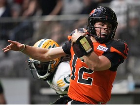 B.C. Lions quarterback Nathan Rourke (12) is pushed out of bounds by Edmonton Elks' Jalen Collins as he runs with the ball during the first half of CFL football game in Vancouver, on Saturday, June 11, 2022.