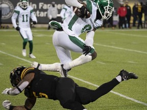 Saskatchewan Roughriders defensive back Elie Bouka (0) goes over Hamilton Tiger Cats running back Don Jackson (5) during second half CFL game action in Hamilton, Ont. on Saturday, Nov. 20, 2021.
