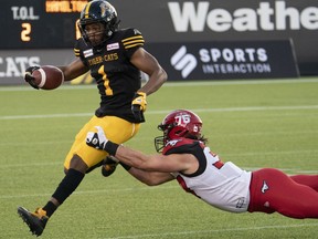 Hamilton Tiger-Cats defensive back Frankie Williams (1) is tackled by Calgary Stampeders fullback Elliot Graham (37) during first half CFL football game action in Hamilton, Ont.  on Friday, September 17, 2021.