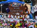 Auf diesem Aktenfoto, das am 28. Mai 2022 aufgenommen wurde, legt ein Mädchen Blumen an einem provisorischen Denkmal an der Robb Elementary School in Uvalde, Texas, nieder. 