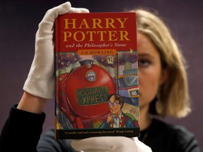 One of the first ever copies of Harry Potter and the Philosopher's Stone by J.K. Rowling, is held by a staff member at Bonhams auctioneers, ahead the Fine Books, Manuscripts, Atlases and Historical Photographs sale in London, March 27, 2019.