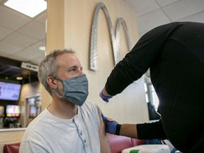 A man receives a booster shot for the coronavirus disease (COVID-19) at a McDonald's as the Omicron variants spreads through the country in Chicago, Illinois, U.S., December 21, 2021.