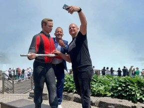Aukšta laidų vaikščiotojas Nikas Wallenda (dešinėje, juodi marškinėliai) ir Niagaros krioklių meras Jimas Diodati pavaizduoti Horseshoe Falls su nauja paroda, skirta pažymėti 10-ąsias Wallenda perėjimo per Niagros krioklį metines.