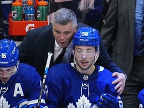 Toronto Maple Leafs head coach Sheldon Keefe congratulates forward Michael Bunting on assisting on the goal by forward Auston Matthews against the Tampa Bay Lightning during the third period of game five of the first round of the 2022 Stanley Cup Playoffs at Scotiabank Arena.