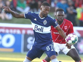 Whitecaps' Tosaint Ricketts (L) and Cavalry FC defender Karifa Yao battle for a loose ball during Canadian Championship soccer action against the Vancouver Whitecaps in Calgary on Wednesday, May 25, 2022.
