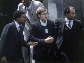 U.S. Marshalls escort John Hinckley Jr. as he returns to a marine base via helicopter in Quantico, Va., Aug. 8, 1981.