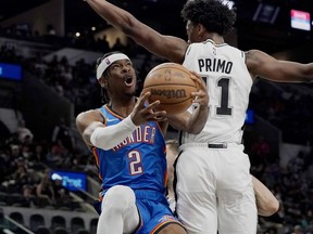 Oklahoma City Thunder guard Shai Gilgeous-Alexander (2) drives to the basket against San Antonio Spurs guard Joshua Primo (11) during the first half of an NBA basketball game, Wednesday, March 16, 2022, in San Antonio.