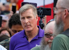 Der Vorsitzende der People's Party of Canada (PPC), Maxime Bernier, hört James Topp zu, ein Veteran der kanadischen Streitkräfte, der aus Protest gegen die COVID-19-Impfstoffmandate durch Kanada marschierte, als er vor dem Canada Day in Ottawa, Ontario, am National War Memorial ankommt. Kanada, 30. Juni 2022.