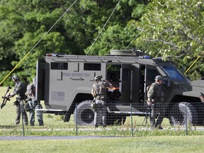 Tactical police work near where a man opened fire at a business, killing three people before the suspect and a state trooper were wounded in a shootout, according to authorities, in Smithsburg, Md., Thursday, June 9, 2022.