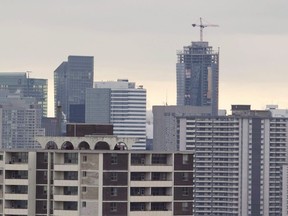 A construction crane sits atop a highrise building in Toronto.