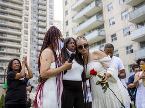 Regis Korchinski-Paquet's mother, Claudette Beals, is comforted after singing at a public memorial and walk for justice held to honour the woman who fell to her death from a balcony while police were in her apartment in Toronto on Saturday July 25, 2020.