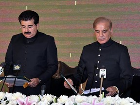 In this photo released by Press Information Department, acting President of Pakistan Sadiq Sanjrani, left, administers the oath of office to newly elected Pakistani Prime Minister Shahbaz Sharif at Presidential Palace, in Islamabad, Pakistan, Monday, April 11, 2022.