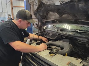Ryan Reil, a service manager seen here working at Downtown Auto Centre in Kitchener, has seen an increase in customers looking to convert their gas-powered vehicles to cheaper propane.