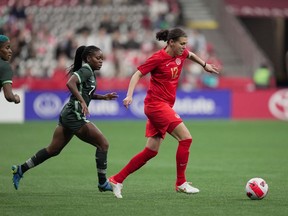 Canada's Christine Sinclair (12) moves the ball while being watched by Nigeria's Toni Payne (7) during the first half of a women's friendly soccer match, in Vancouver, on Friday, April 8, 2022.