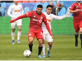 Mar 5, 2022; Toronto, Ontario, CAN;   Toronto FC midfielder Alejandro Pozuelo (10) dribbles the ball away from New York Red Bulls midfielder Frankie Amaya (8) in the first half at BMO Field.