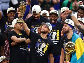 Stephen Curry of the Golden State Warriors lifts the Bill Russell NBA Finals Most Valuable Player Award after defeating the Boston Celtics 103-90 in Game 6 of the 2022 NBA Finals at TD Garden on June 16, 2022 in Boston.