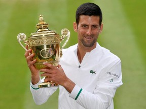 Tennis - Wimbledon - All England Lawn Tennis and Croquet Club, London, Britain - July 11, 2021 Serbia's Novak Djokovic celebrates with the trophy after winning his final match against Italy's Matteo Berrettini.