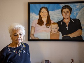 Donna Casasanta poses in front of a painting showing her late son, Harold Dean Clouse, with Clouse's wife, Tina Gail Linn, and their daughter, Hollie Marie Clouse, at Casasanta's Edgewater, Fla., home on Friday, Jan. 14, 2022.