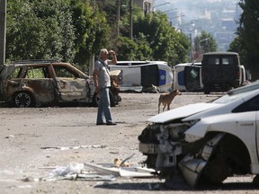 A man stands by a barricade made with destroyed police cars in Lysychansk on June 21, 2022.