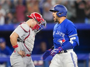George Springer of the Toronto Blue Jays celebrates his grand slam in front of Andrew Knizner of the St. Louis Cardinals in the sixth inning during their MLB game at the Rogers Centre on July 26, 2022 in Toronto, Ontario, Canada.