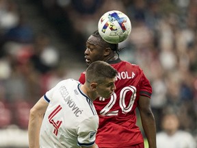Ayo Akinola of the Toronto FC flicks the ball past Ranko Veselinovic of the Vancouver Whitecaps FC during the second half of the 2022 Canadian Championship Final at BC Place on July 26, 2022 in Vancouver, British Columbia.