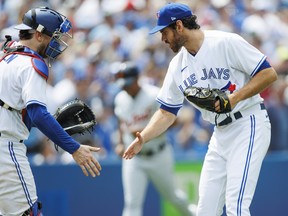 Blue Jays' Danny Jansen (left) and Jordan Romano celebrate after the Jas defeated the Detroit Tigers at Rogers Centre on Sunday, July 31, 2022 in Toronto.