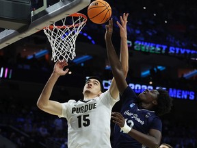 Zach Edey #15 of the Purdue Boilermakers and Clarence Rupert #12 of the St. Peter's Peacocks jump for the ball in the first half of the game in the Sweet Sixteen round of the 2022 NCAA Men's Basketball Tournament at Wells Fargo Center on March 25, 2022 in Philadelphia, Pennsylvania.