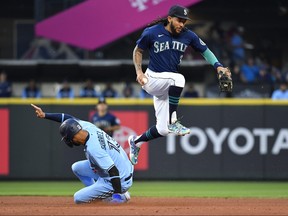 J.P. Crawford of the Seattle Mariners leaps after getting a force out on Lourdes Gurriel Jr. of the Toronto Blue Jays during the fifth inning at T-Mobile Park on Saturday night.
