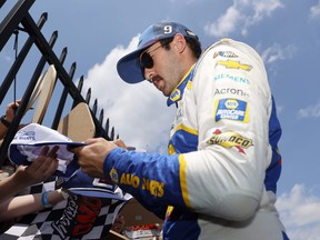 Chase Elliott, driver of the #9 NAPA Auto Parts Chevrolet, signs autographs for fans in the garage area prior to the NASCAR Cup Series M&M's Fan Appreciation 400 at Pocono Raceway on July 24, 2022 in Long Pond, Pennsylvania.