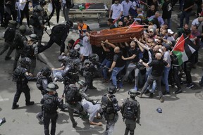 Die israelische Polizei konfrontiert Trauernde, die den Sarg der getöteten Al Jazeera-Veteranenjournalistin Shireen Abu Akleh während ihrer Beerdigung in Ost-Jerusalem am Freitag, den 13. Mai 2022 tragen. (AP Photo/Maya Levin, Akte)