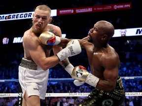 Floyd Mayweather Jr. throws a punch at Conor McGregor during their super welterweight boxing match on August 26, 2017 at T-Mobile Arena in Las Vegas, Nevada.