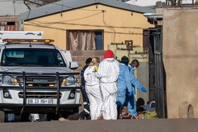 Members of the South African Police Service (SAPS) and forensic pathology service inspect the scene of a mass shooting in Soweto, South Africa, on July 10, 2022.