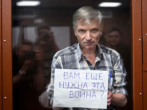 Alexei Gorinov, accused of spreading "knowingly false information" about the Russian army fighting in Ukraine, stands with a poster reading ""Do you still need this war?" inside a glass cell during the vedict hearing in his trial at a courthouse in Moscow on July 8, 2022.