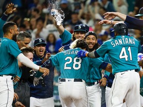 Seattle Mariners third baseman Eugenio Suarez (28) celebrates with teammates after hitting a walk-off three-run home run against the Toronto Blue Jays during the eleventh inning at T-Mobile Park.