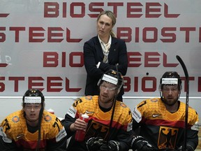 Germany's assistant coach Jessica Campbell stands behind players at the German bench during the group A Hockey World Championship match between France and Germany in Helsinki, Finland, Monday May 16, 2022.