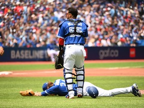 Toronto Blue Jays' catcher Gabriel Moreno (55) checks on starting pitcher Kevin Gausman after Gausman was hit by a batted ball off the bat of a Tampa Bay Rays batter in second inning American League baseball action in Toronto, Saturday, July 2, 2022. Gausman would leave the game, though X-rays were negative.