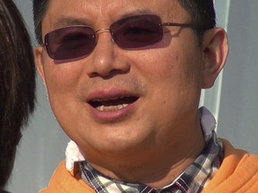 Xiao Jianhua, a Chinese-born Canadian billionaire, talks to reporters outside the International Finance Centre in Hong Kong in December 2013.