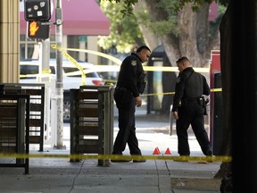 Sacramento Police officers look over evidence markers near the scene of a fatal shooting outside of a downtown Sacramento, Calif., night club in the early morning hours on Monday, July 4, 2022.