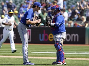 Le coser Jordan Romano salue le receveur Alejandro Kirk après que les Blue Jays ont battu les Oakland Athletics 2-1 à Oakland le mercredi 6 juillet 2022.