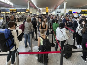 Travellers queue at security at Heathrow Airport in London, Wednesday, June 22, 2022.