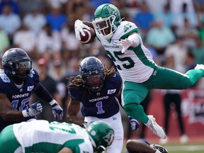 Riders’ Jamal Morrow, leaping over the pack in front of Argos’ Wynton McManis (left) and Shaq Richardson last Saturday in Nova Scotia, managed 106 rushing and receiving yards against the steadily improving Toronto defence.