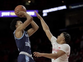 Rhode Island guard Jeff Dowtin, left, shoots against Maryland guard Anthony Cowan Jr. during the second half of an NCAA college basketball game, Saturday, Nov. 9, 2019, in College Park, Md.