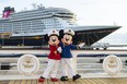 Minnie and Mickey Mouse stand outside the Disney Wish.