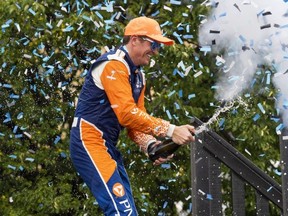 Scott Dixon of New Zealand celebrates with champagne in the winners circle after winning the 2022 Honda Indy Toronto Sunday. Mark Blinch/The Canadian Press