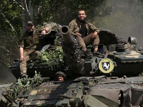 Ukrainian soldiers ride a tank on a road in the Donetsk region on July 20, 2022, near the front line between Russian and Ukrainian forces.